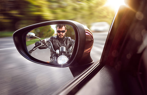 bigstock-Biker-in-rear-view-mirror-76521551