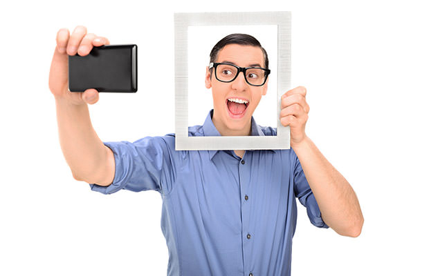bigstock-Man-taking-a-selfie-and-holdin-62873521